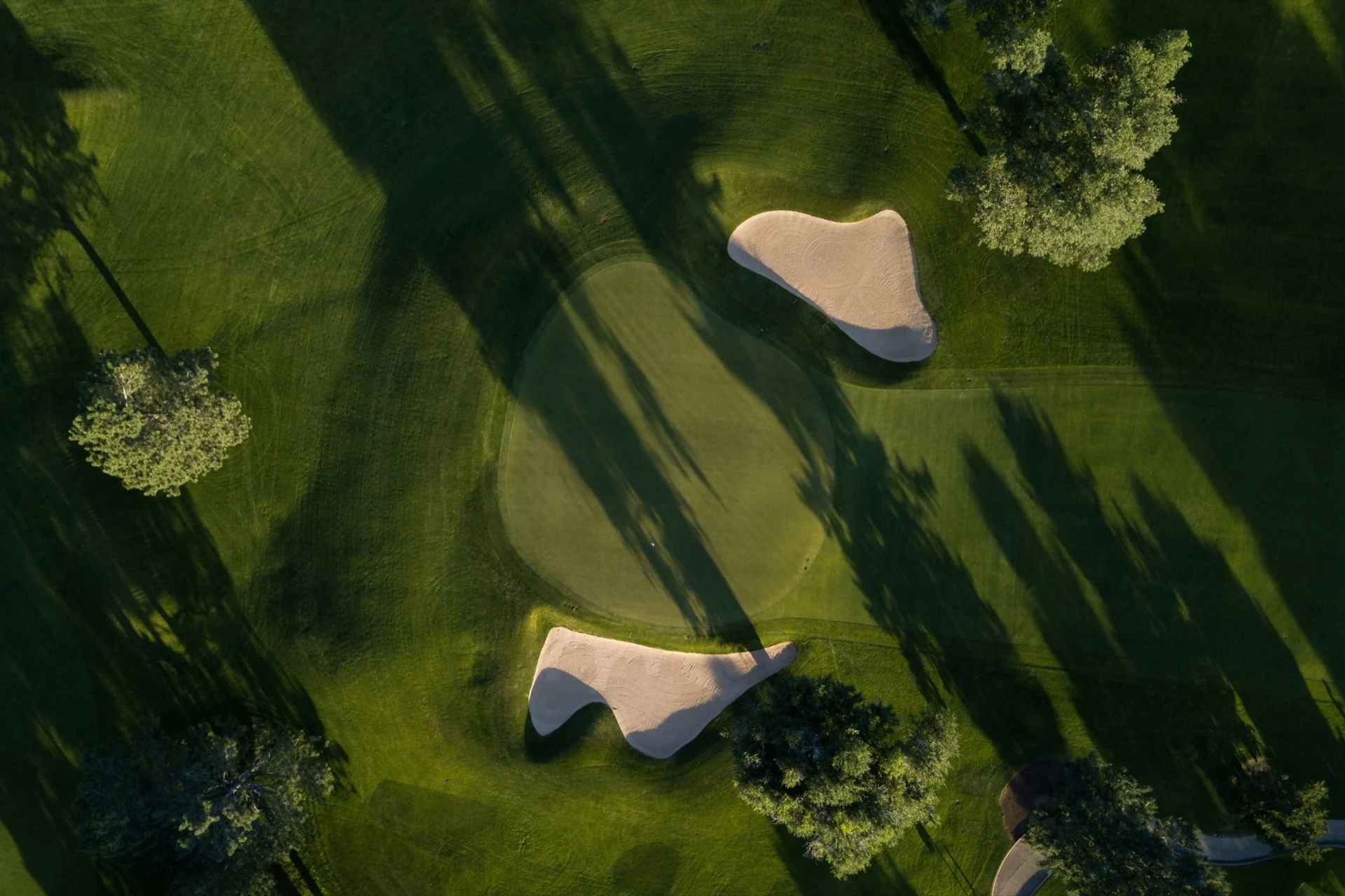 An aerial view of a golf green and bunkers