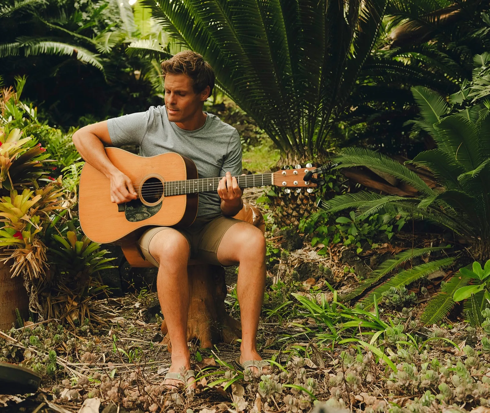 Seth Marcus playing acoustic guitar outdoors